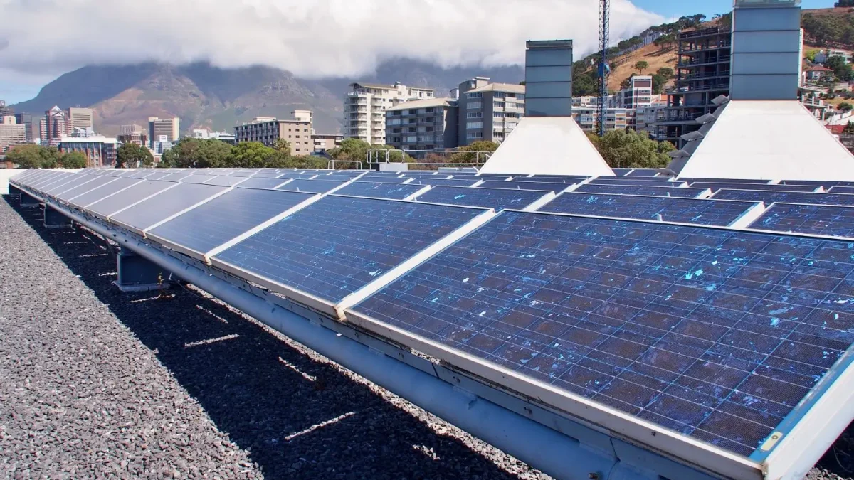 Solar panels installed on a Cape Town rooftop with Table Mountain and city skyline in the background