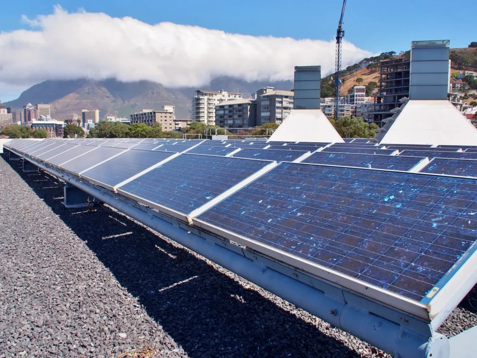 Solar panels installed on a Cape Town rooftop with Table Mountain and city skyline in the background